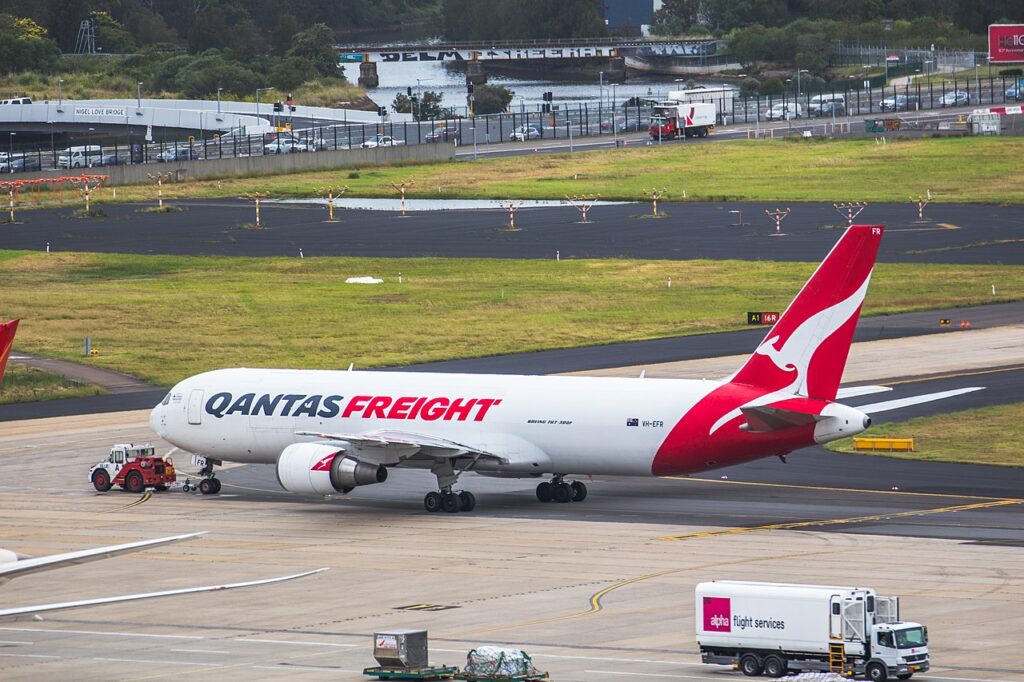 A Qantas Cargo freighter is towed on the tarmac.