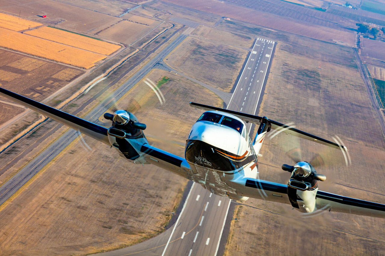 A Beechcraft King Air 360 climbs steeply after takeoff.
