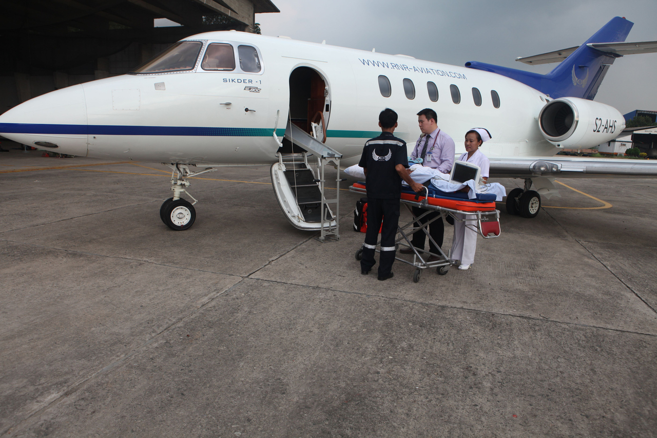 A person on a stretcher is loaded into a private jet on a medevac flight.