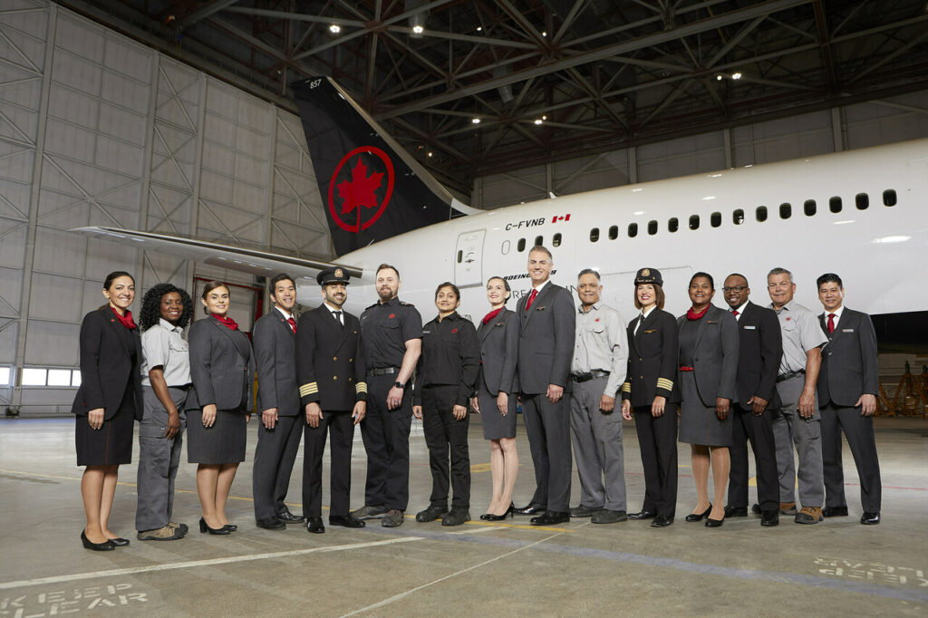 Air Canada staff pose with an aircraft in the hangar
