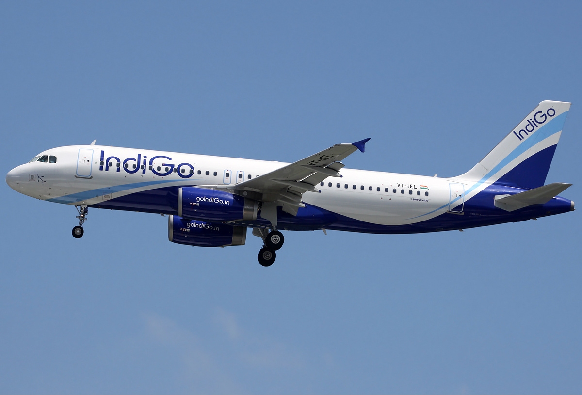 An IndiGo Airbus A320 approaches with wheels down.