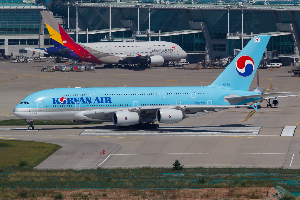 A Korean Air Airbus taxis past an Asiana Airlines A380.