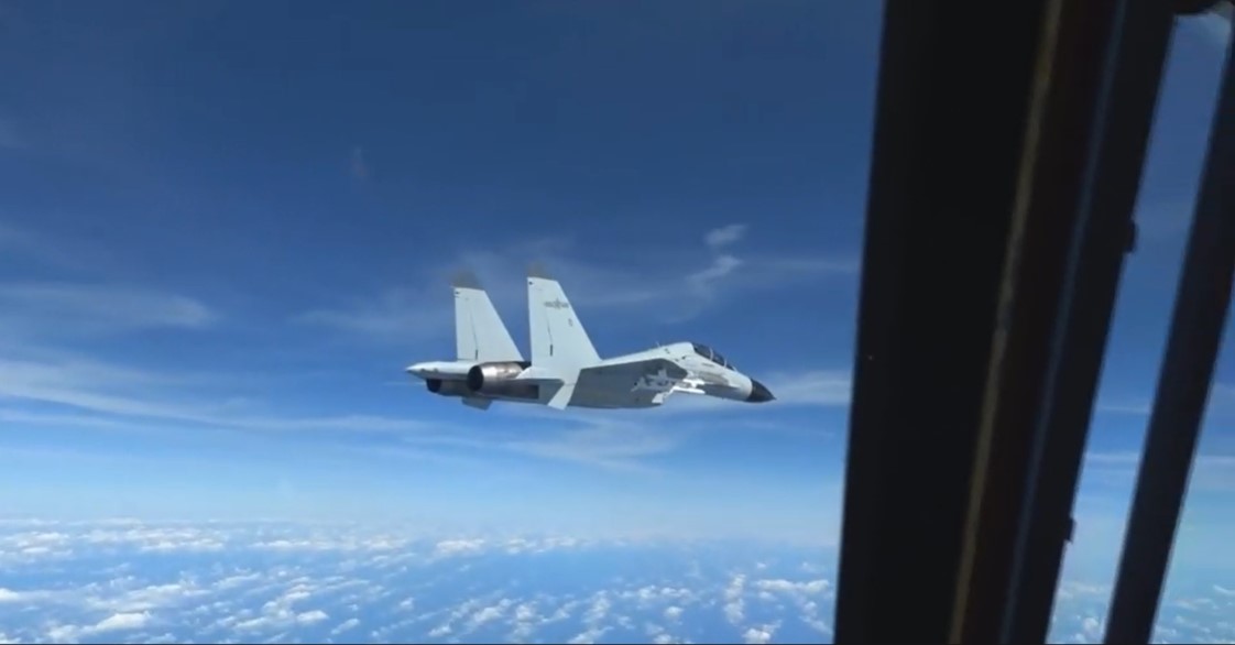 A Chinese fighter aircraft flies dangerously close to a US Air Force Recon aircraft.