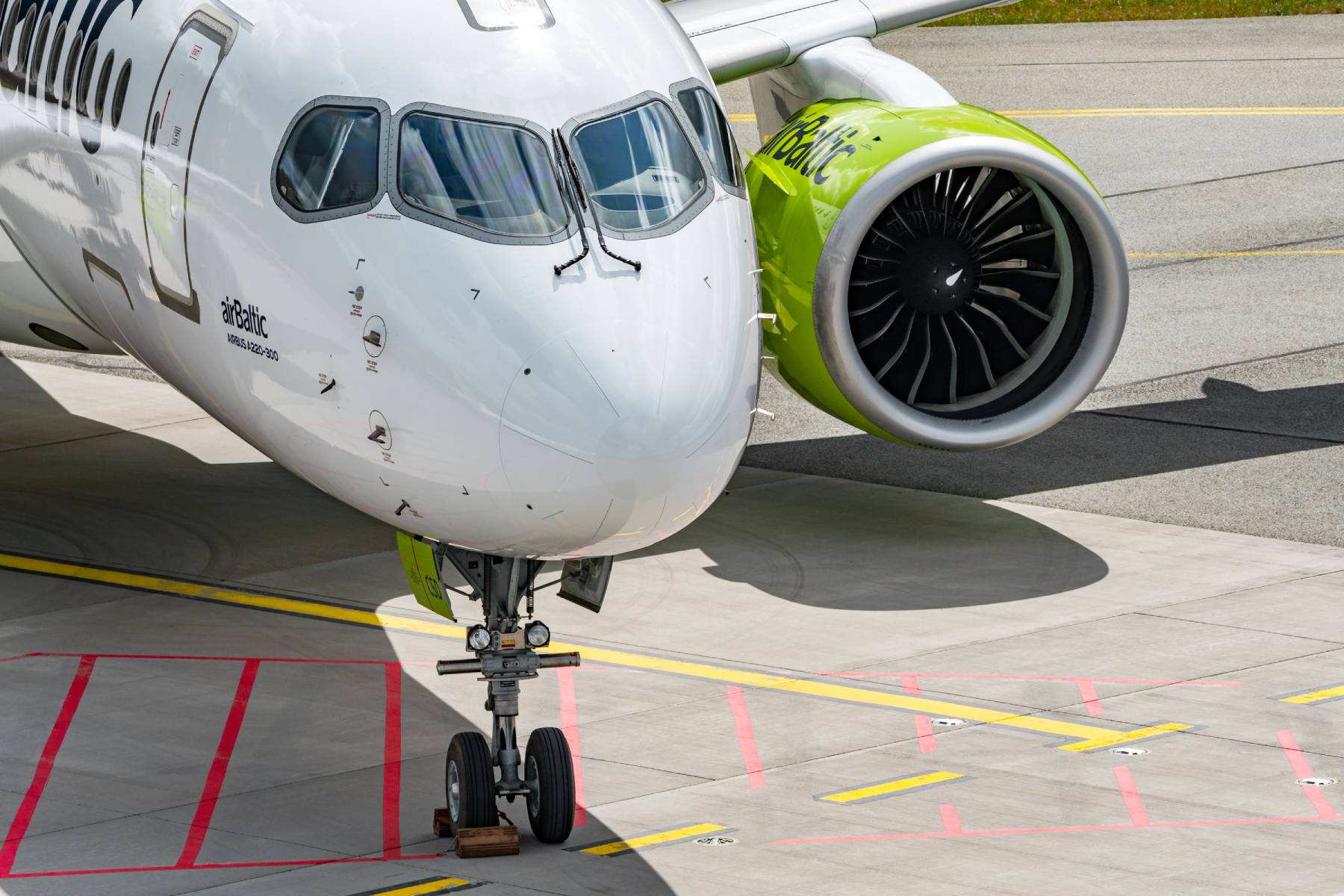 Close-up of the nose of an airBaltic A220 aircraft.