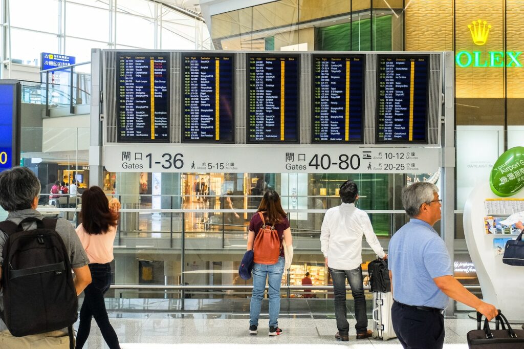 An airport terminal with Arrivals and Departures board.