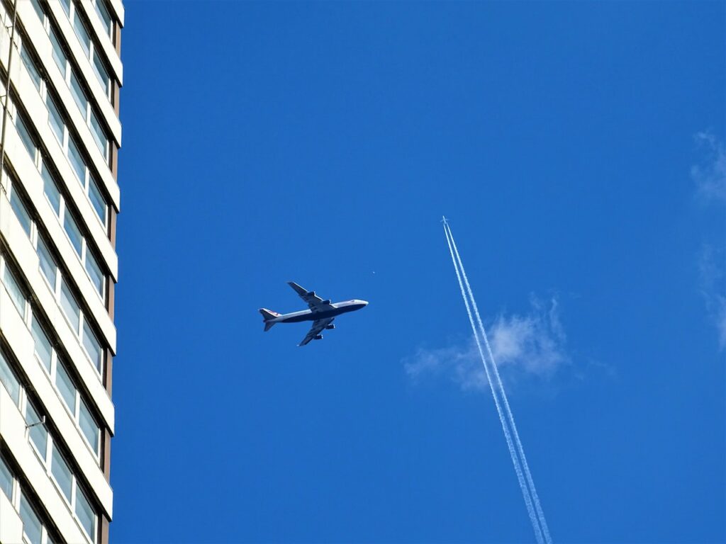 An airliner passes under the contrails of another flight.