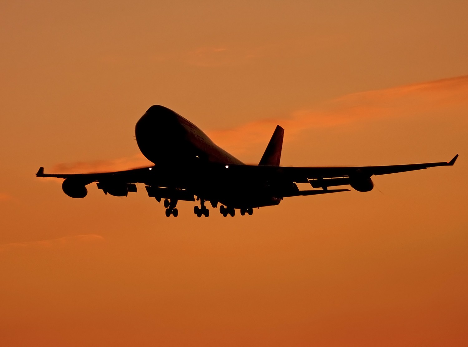 A Boeing 747 silhouetted against the evening sky.