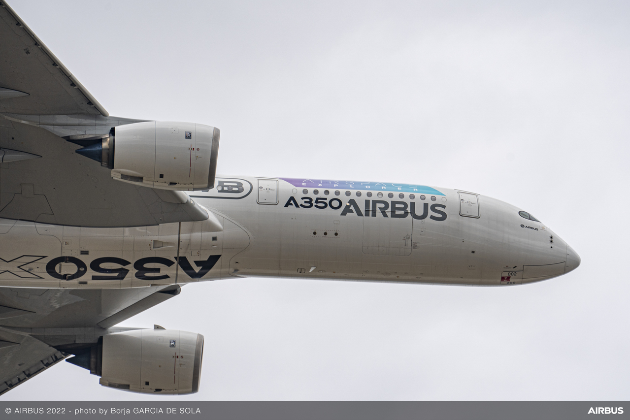 An Airbus A350 passes overhead on a demo flight.