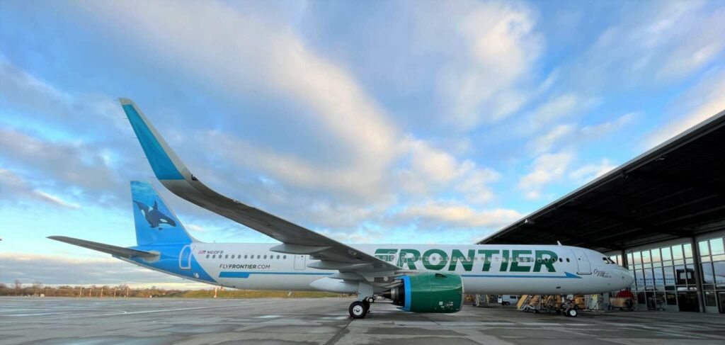 A Frontier Airlines Airbus A321neo parked in front of the hangar.