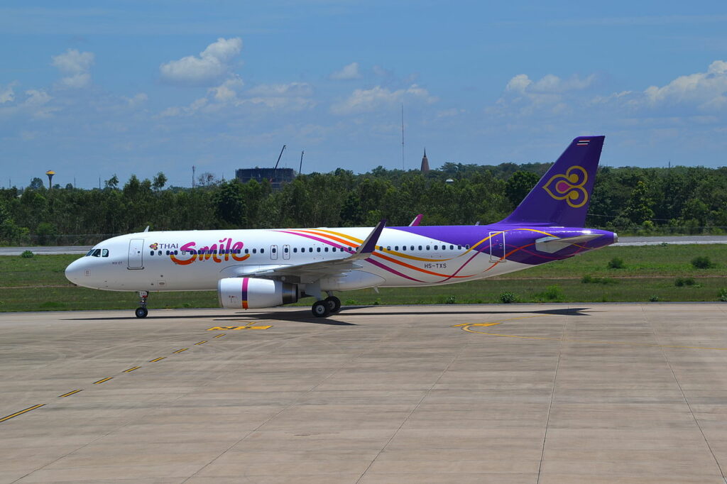A Thai Smile Airbus A320 parked on the tarmac.