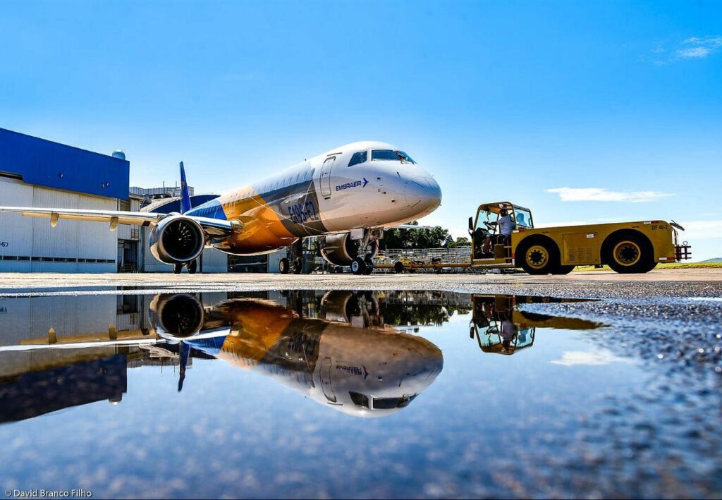 An Embraer E2 jet parked in front of the hangar.