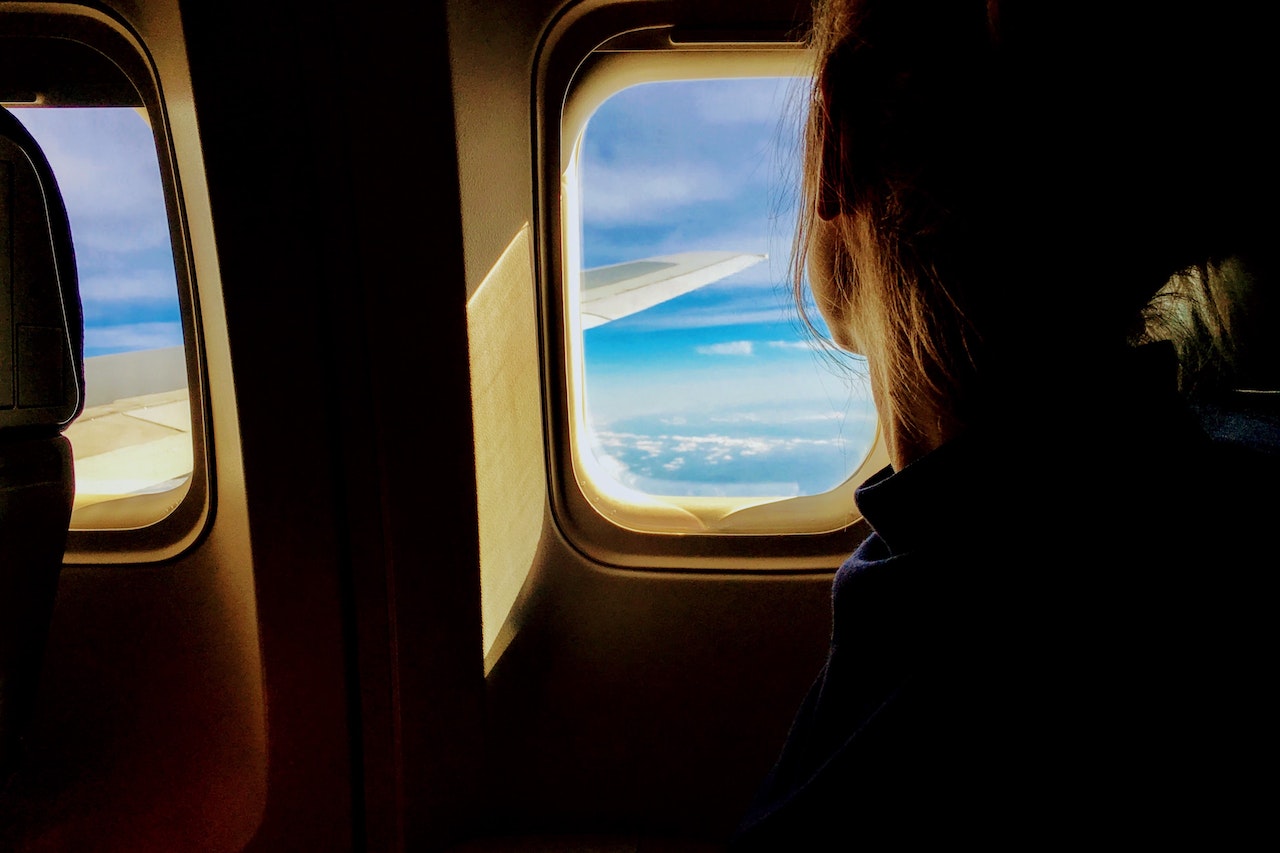 A passenger looks out the cabin window of an airliner.
