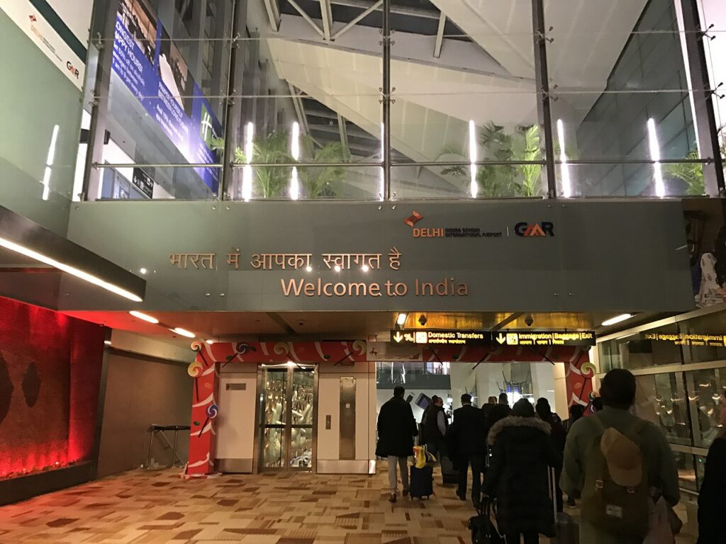 Air passengers enter Delhi Airport terminal building.