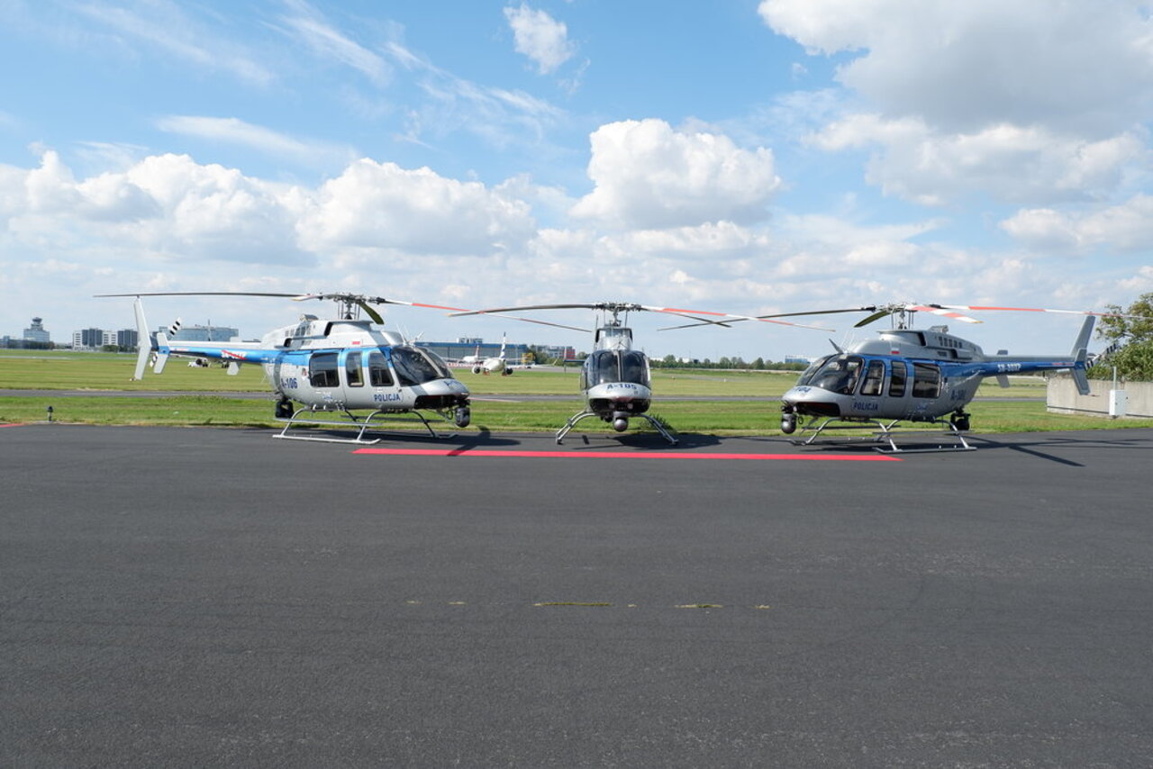 3 Polish National Police Bell 407GXi helicopters parked on the tarmac.