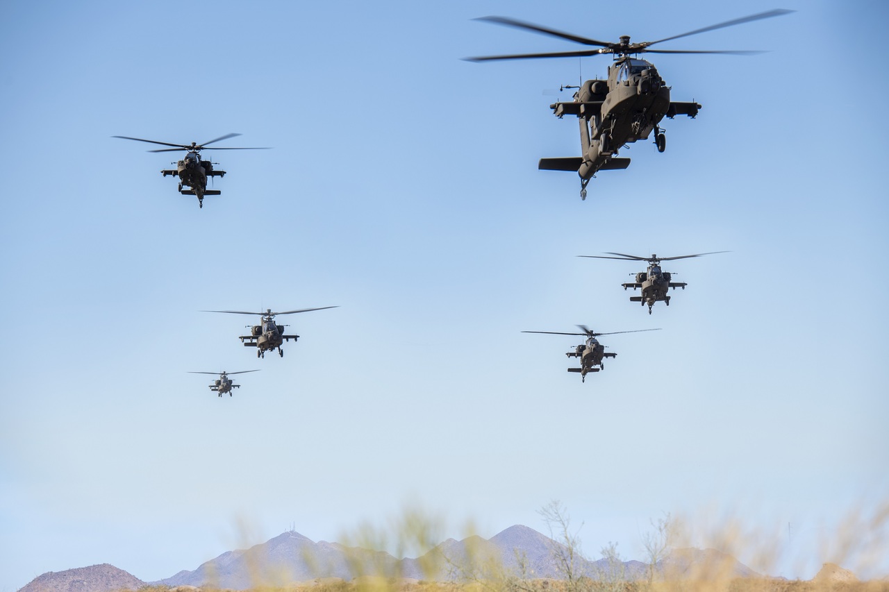Six US Army Apache helicopters fly two abreast.