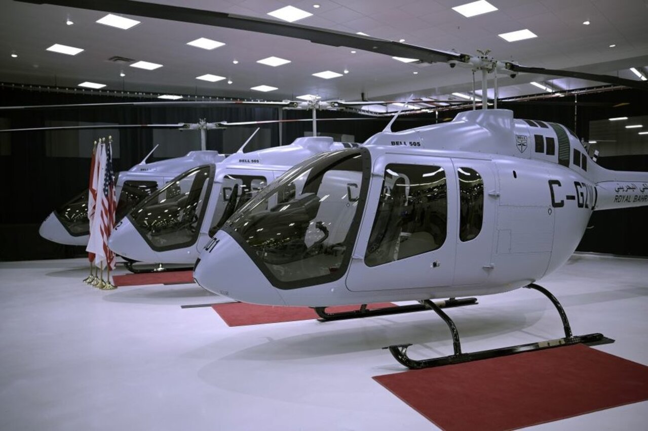 Three Bahrain Air Force Bell 505 helicopters parked in the hangar