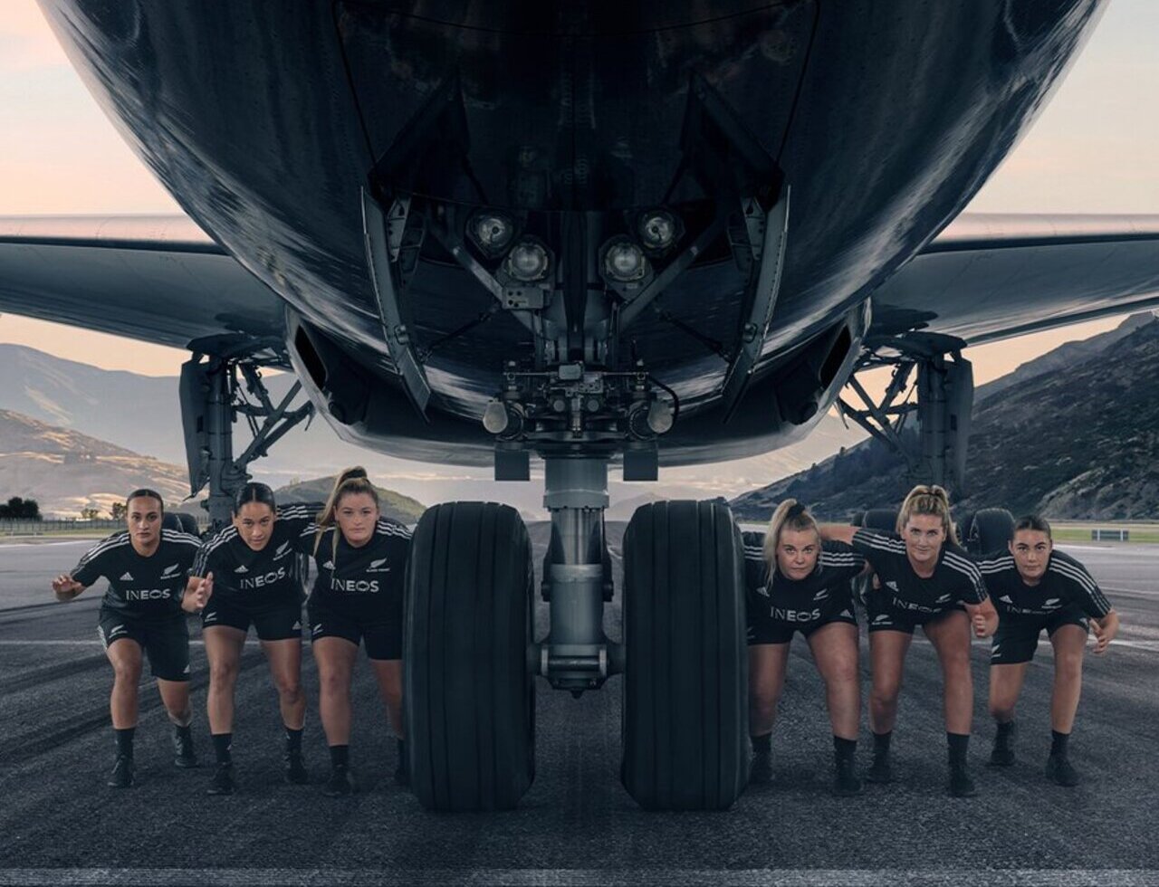 Team members of the Black Ferns pose with an Air New Zealand aircraft.