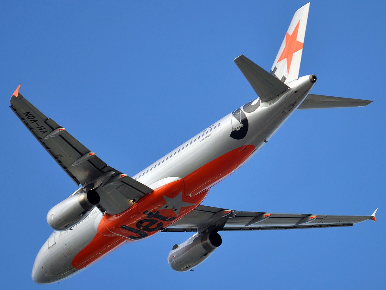 A Jetstar Airbus A320 passes overhead.