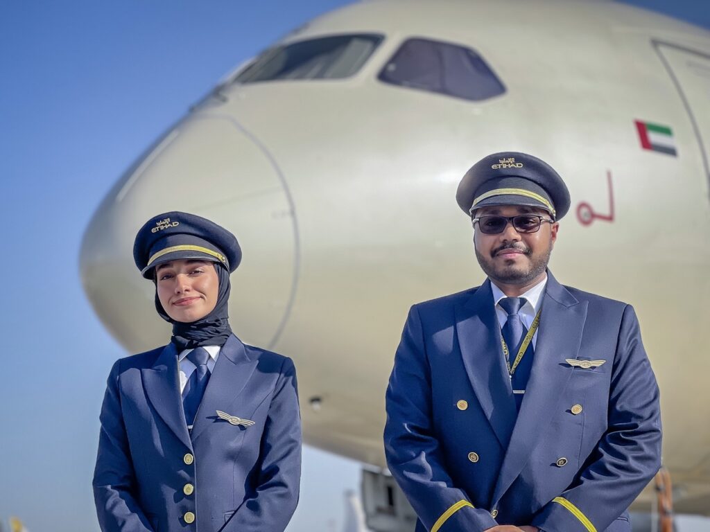Etihad Airways cadet pilots pose in front of Etihad aircraft.
