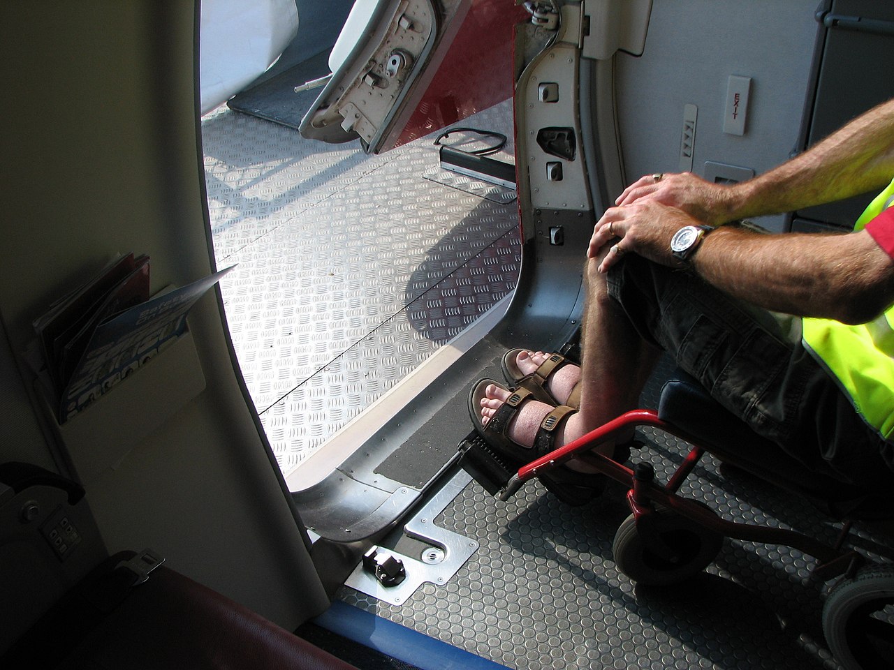 A passenger in a wheelchair boards an aircraft.