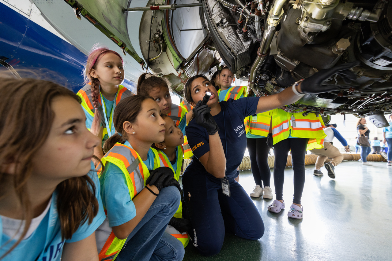 Female students look at a JetBlue aircraft at Fly Like A Girl career day event.