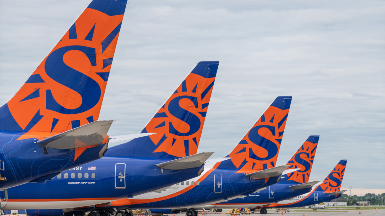 The tails of five parked Sun Country Airlines aircraft.