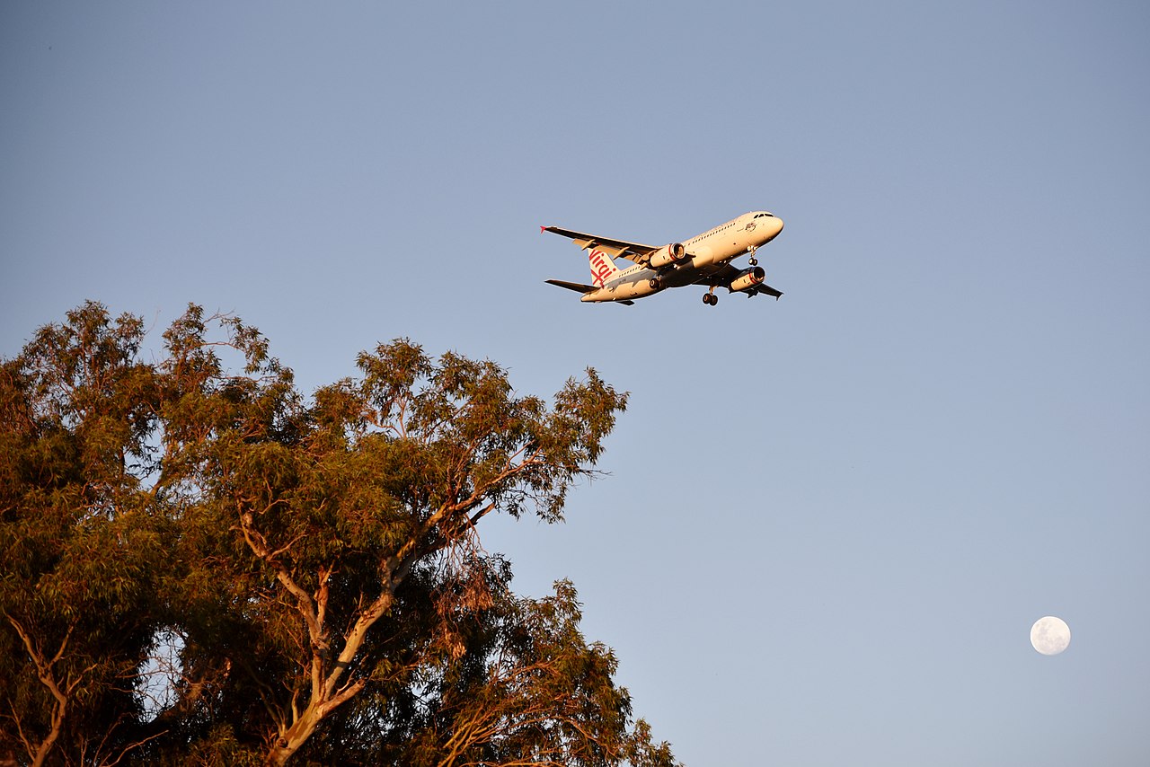 A Virgin Australia flight approaches Perth, Western Australia in twilight.