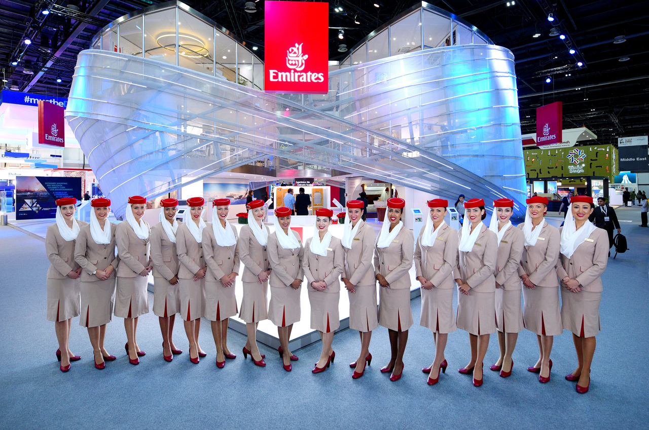Emirates staff pose at the Arabian Travel Market exhibition display