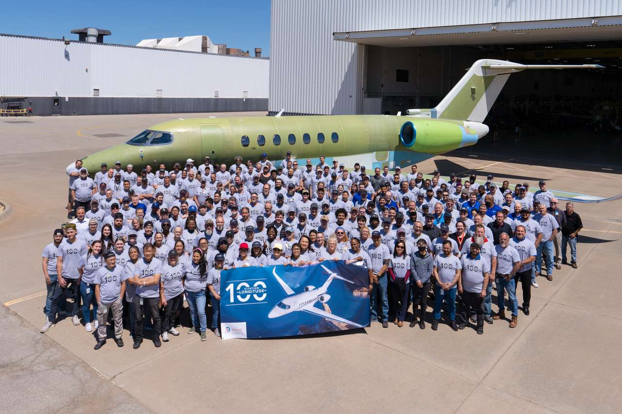 Workers gather in front of 100th Cessna Citation Longitude aircraft.