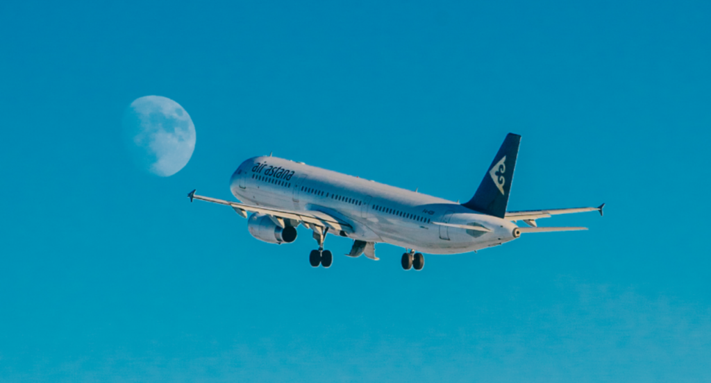An Air Astana jet climbs out with the moon in the background