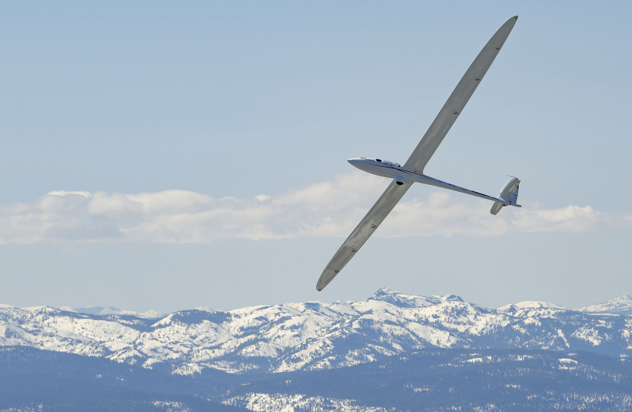 The Airbus Perlan Mission II glider soars over mountains.