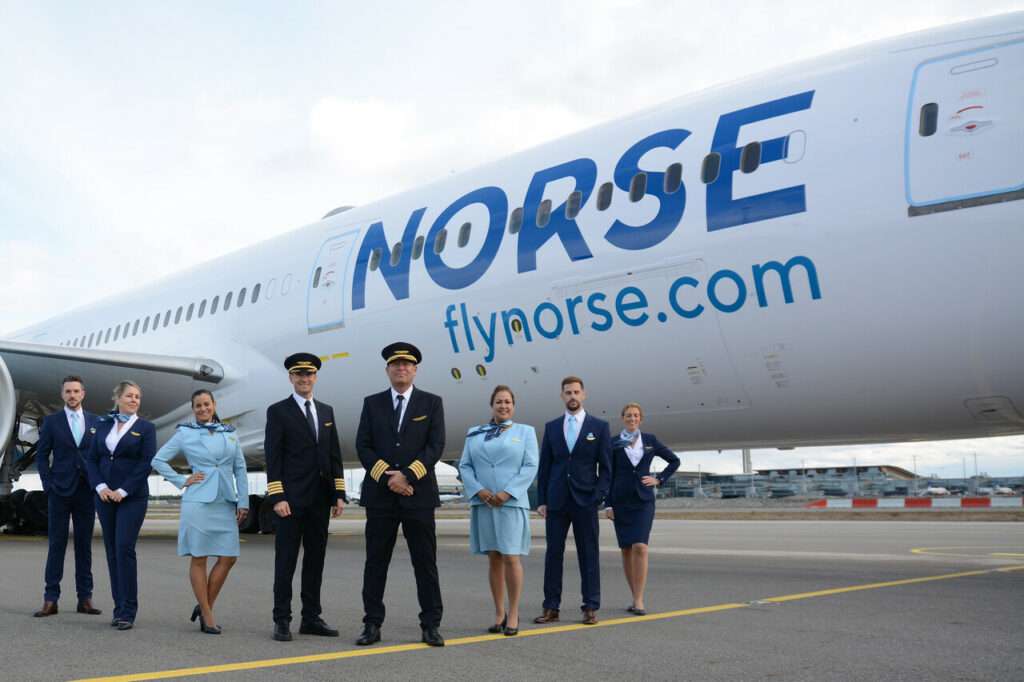 Flight and cabin crew stand in front of a Norse Atlantic Airways Boeing 787.