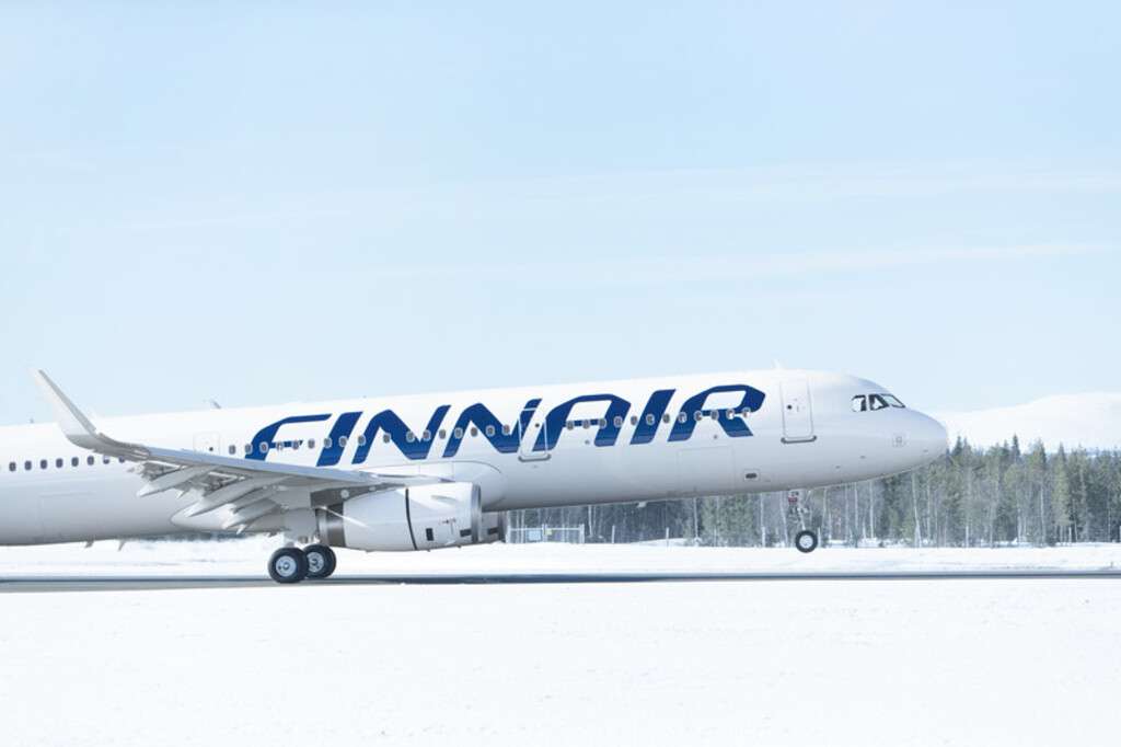 A Finnair A320 takes off in the snow.