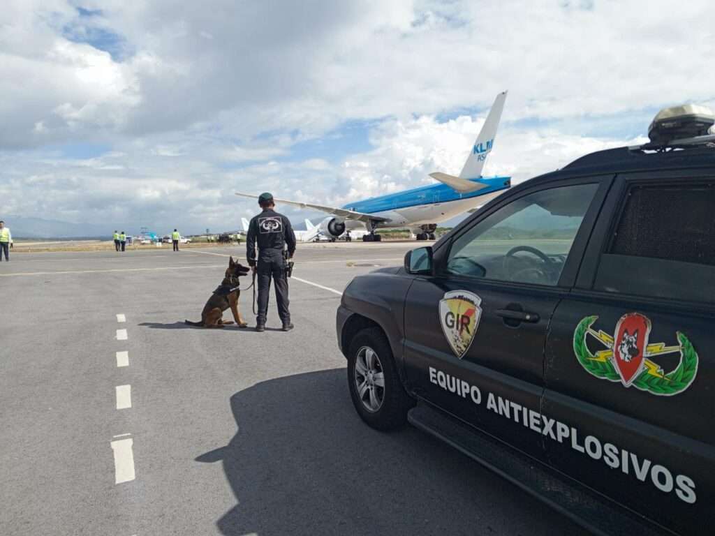Ecuador Police watch a KLM flight park at the airport following a bomb threat.