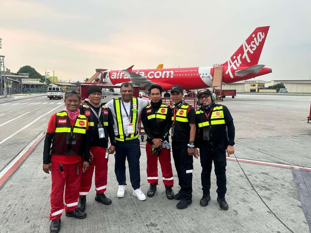 AirAsia Philippines ground crew pose with CEO in front of aircraft.