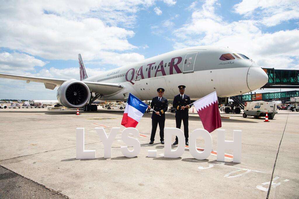 Flight crew stand with a Qatar Airways Boeing 787 at Lyon Airport.