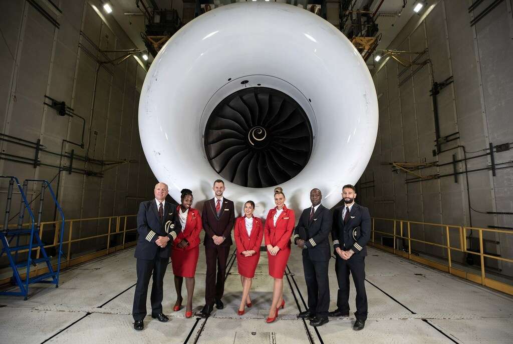Virgin Atlantic staff stand in front of a Rolls-Royce engine.