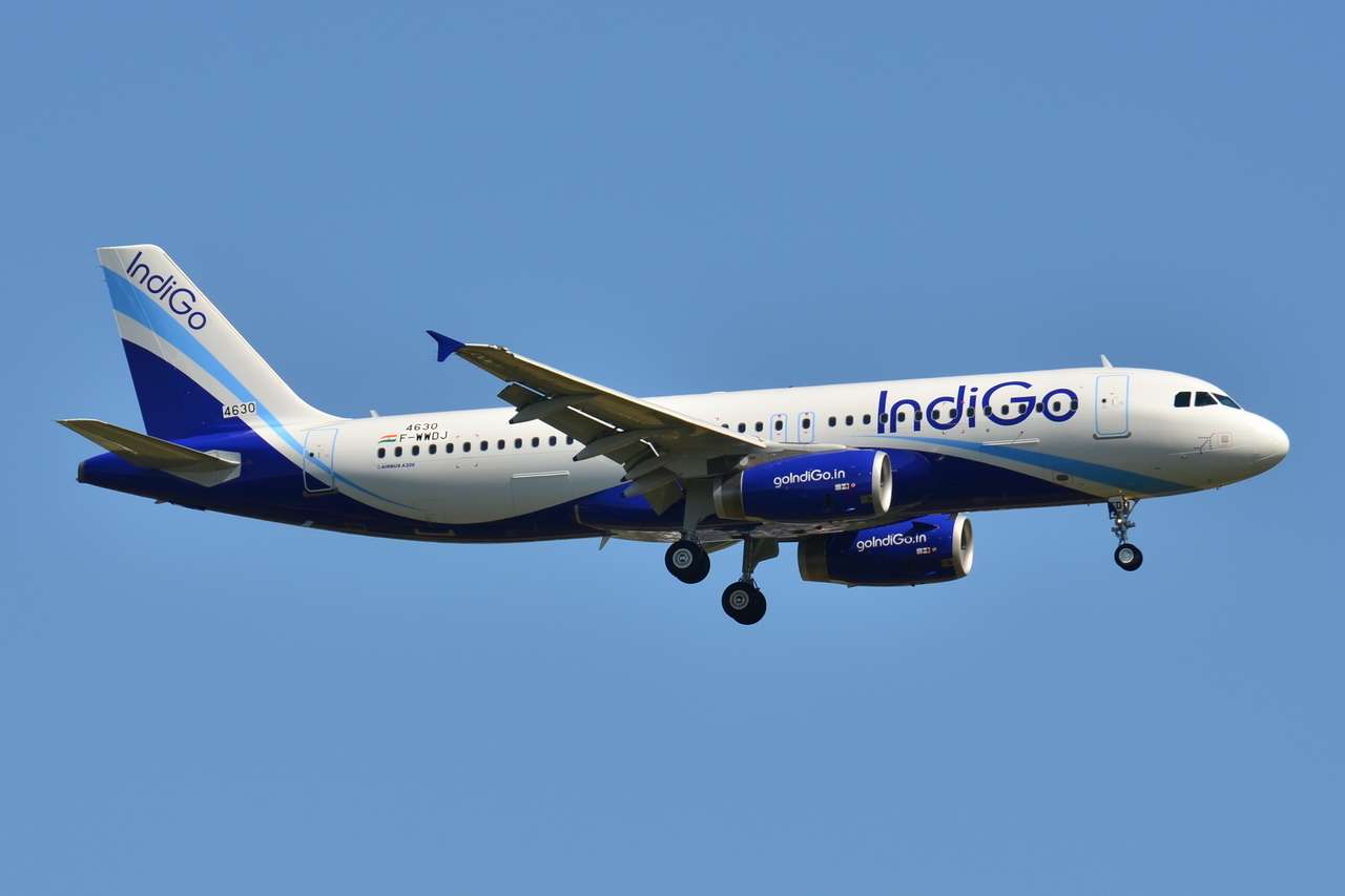 An IndiGo Airbus approaches with wheels down.