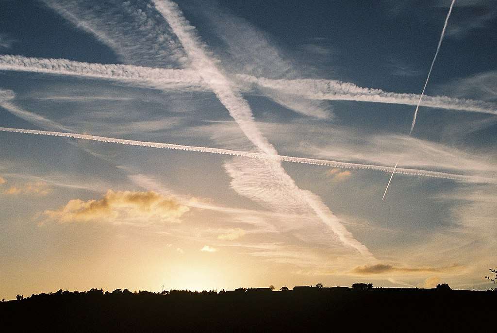 Contrails criss-cross the sky at dusk.