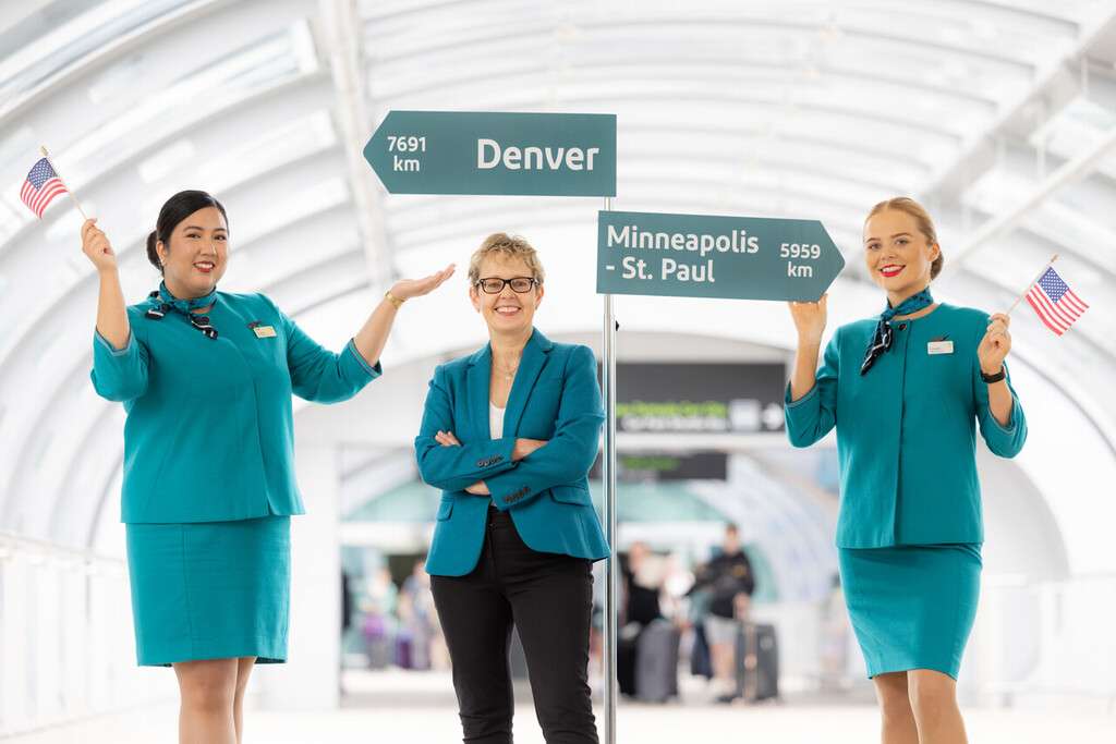 Aer Lingus CEO and cabin crew with Denver and Minneapolis-St.Paul signs.