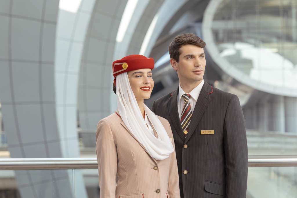 Two Emirates cabin crew members in uniform.