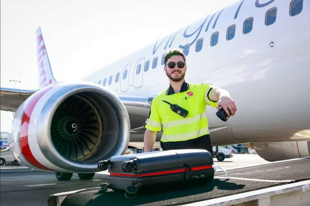 Virgin Australia ground handler with baggage tracker.