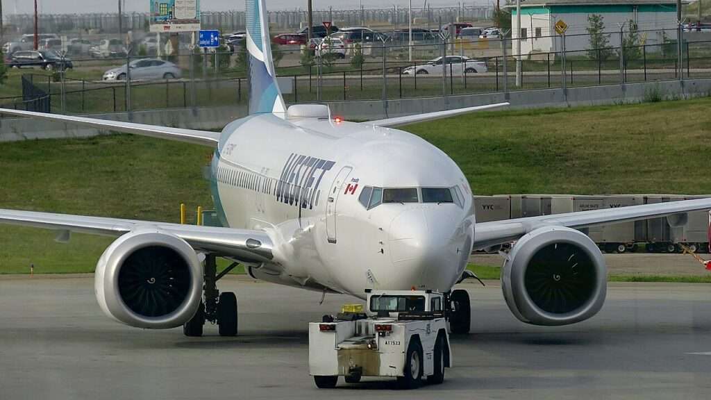 A WestJet Boeing 737 being pushed back at Calgary Airport.