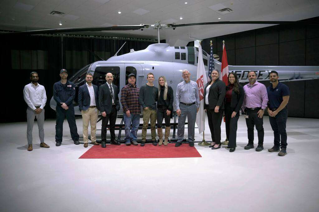 Bell Textron staff with the 505th Bell 505 helicopter in the hangar.