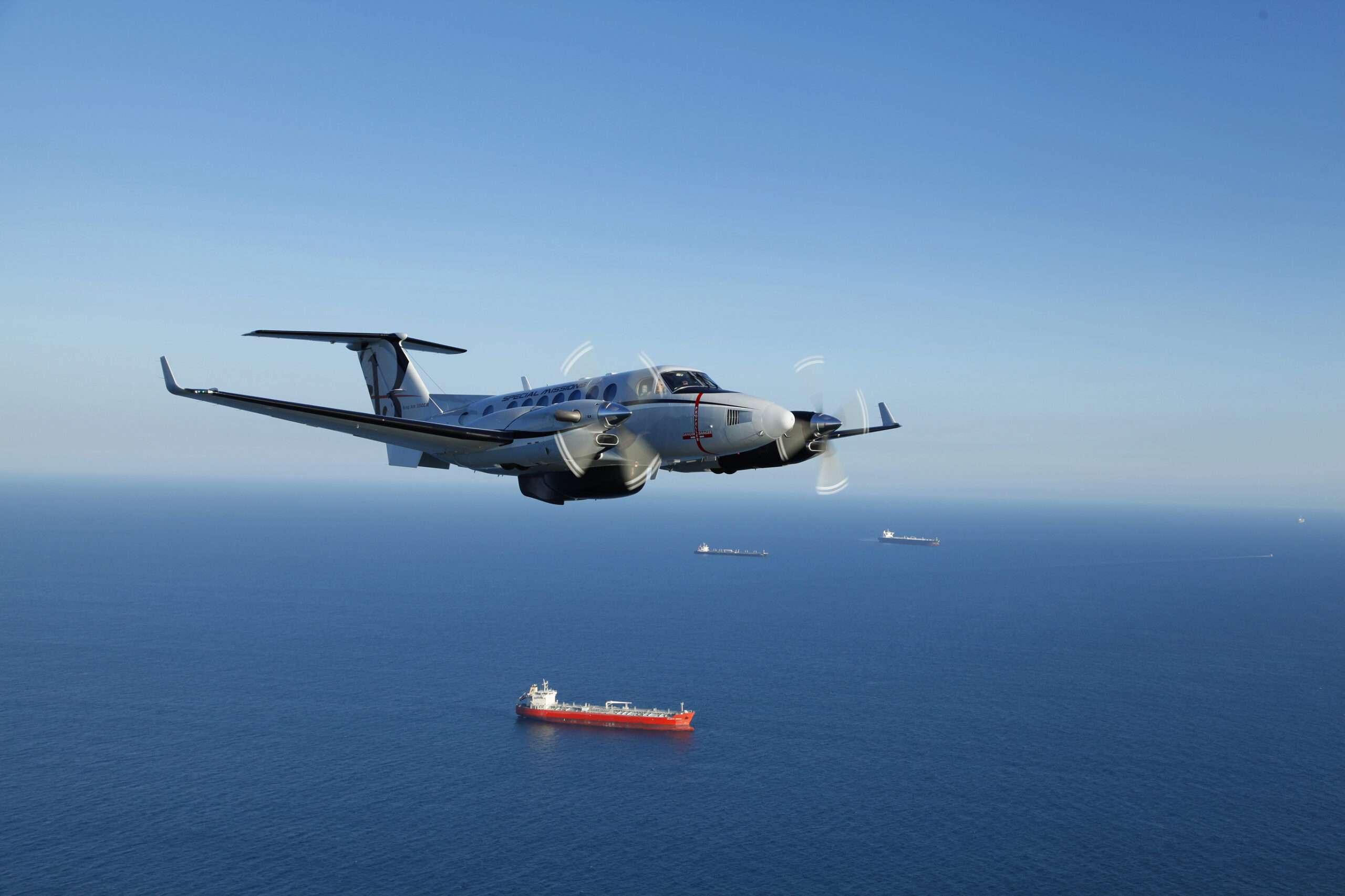 A US Army special mission Beechcraft King Air 360 in flight over sea.