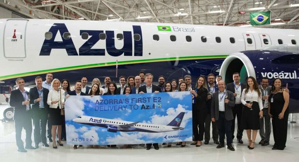 Azul airline staff with a new E195-E2 jet in the hangar.