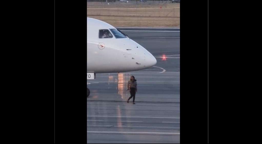 A woman walks out to a Qantaslink aircraft at Canberra Airport.