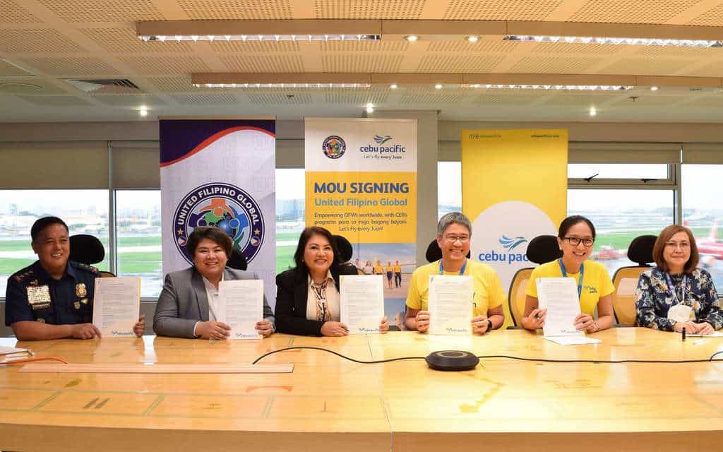 A delegation of Cebu Pacific and UFG reps sign an MOU.