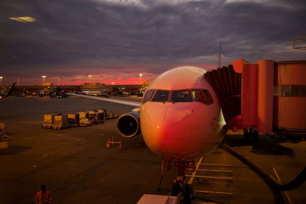 A jet parked at the terminal at sunset.