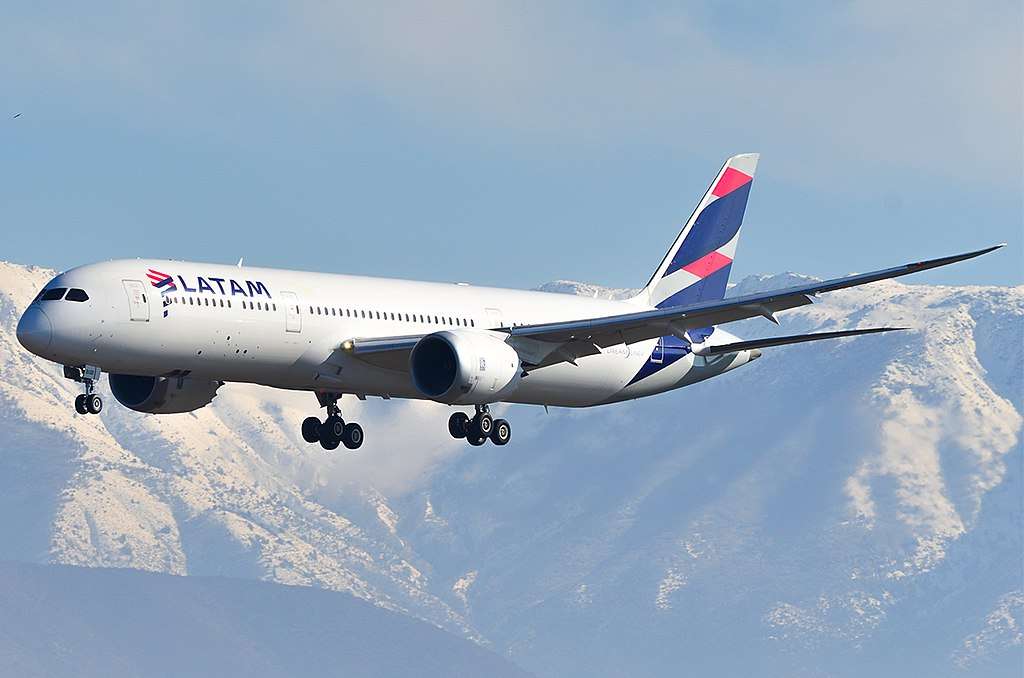 A LATAM Boeing 787 approaches over mountains.